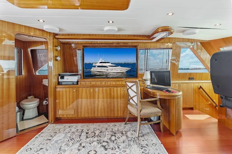 Slide: The Image of Luxurious 2005 Horizon 82 yacht interior with wood paneling, desk, and ocean view. - 48