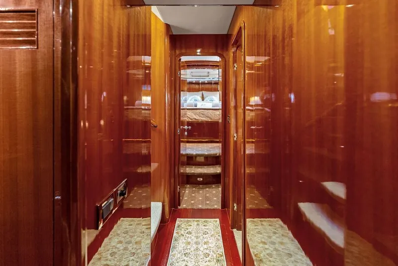 Slide: The Image of Luxurious wooden interior hallway of a 2005 Horizon 82 yacht, leading to a cozy bedroom. - 51
