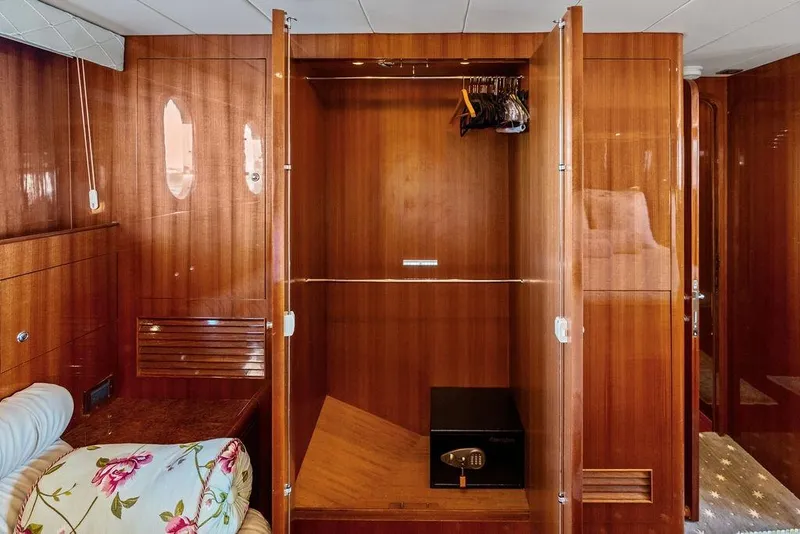 Slide: The Image of Luxurious wooden yacht interior closet with safe, hangers, and floral cushion. Horizon 82, 2005 model. - 55
