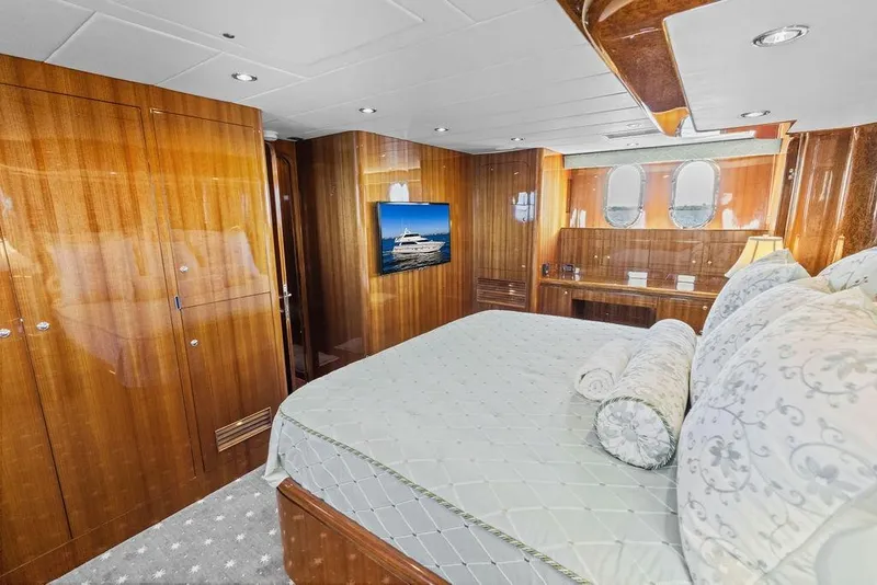 Slide: The Image of Luxurious 2005 Horizon 82 yacht bedroom with elegant wood paneling and plush bedding. - 57