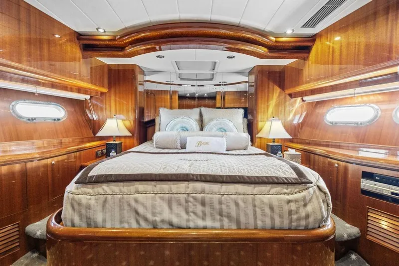 Slide: The Image of Luxurious 2005 Horizon 82 yacht bedroom with elegant wood paneling and ambient lighting. - 69