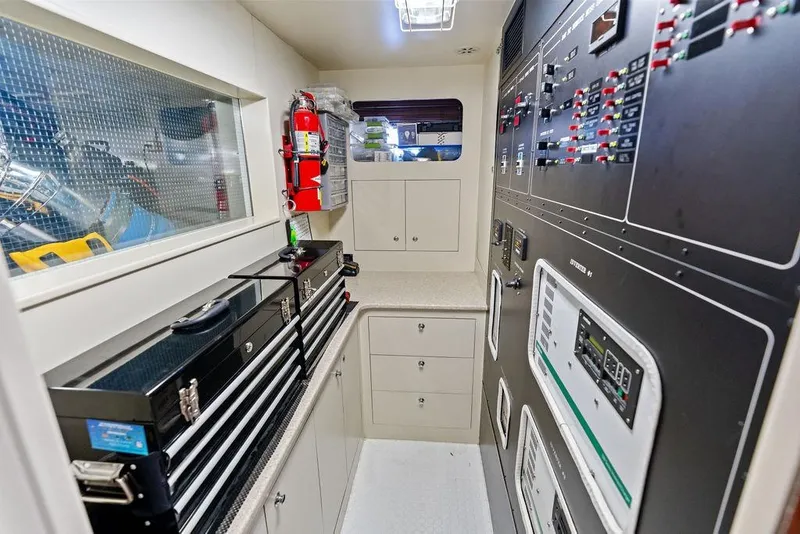Slide: The Image of Engine room of 2005 Horizon 82 yacht with toolboxes and control panels. - 78