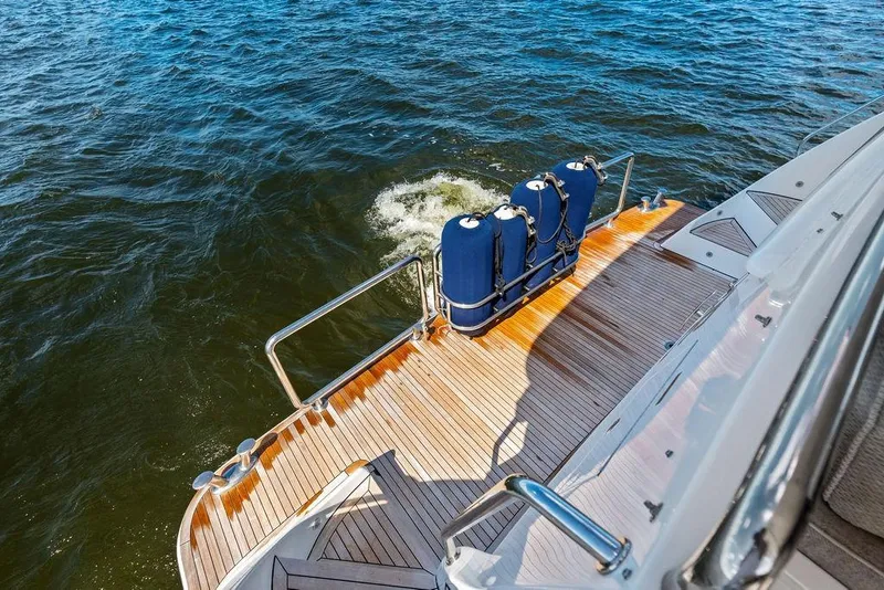 Slide: The Image of Luxury yacht deck with wooden finish, Horizon 82 model, 2005, overlooking ocean waters. - 8