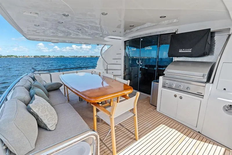 Slide: The Image of Luxurious 2005 Horizon 82 yacht deck with seating, dining table, and grill overlooking the ocean. - 9