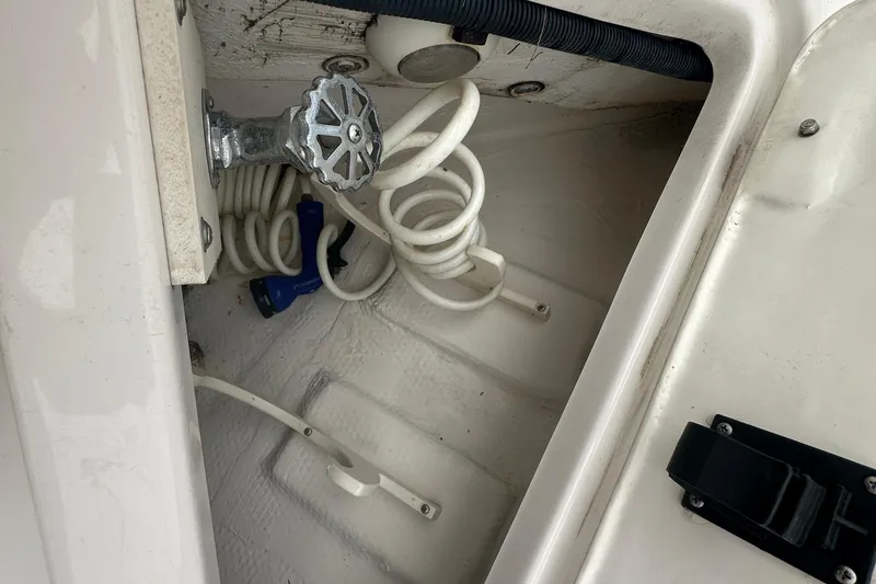 Slide: The Image of Storage compartment of a 2016 Regal 35 Sport Coupe with coiled hose and valve. - 43