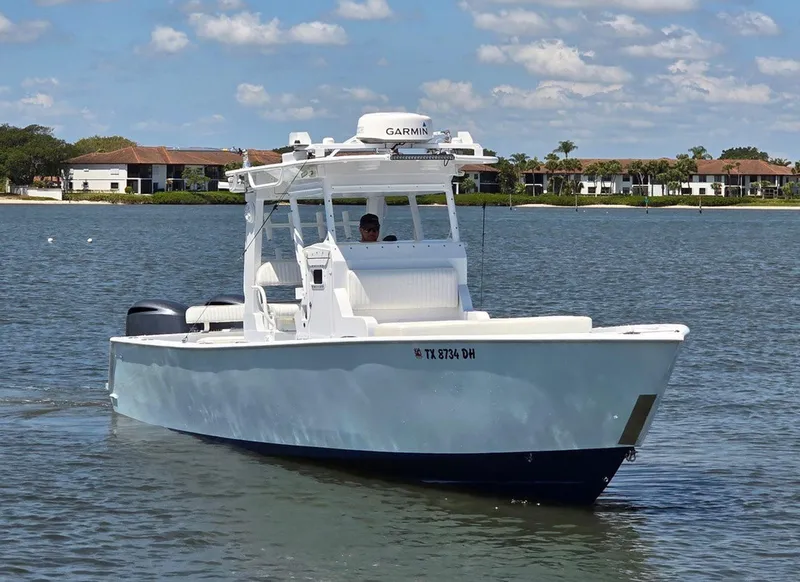 Slide: The Image of 2012 Contender Custom 33 Center Console boat on calm water, clear sky background. - 2