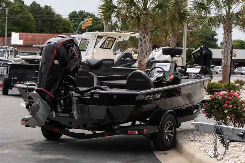 Slide: The Image of 2023 Vexus AVX1880 boat on trailer, parked near palm trees and flowers. - 6