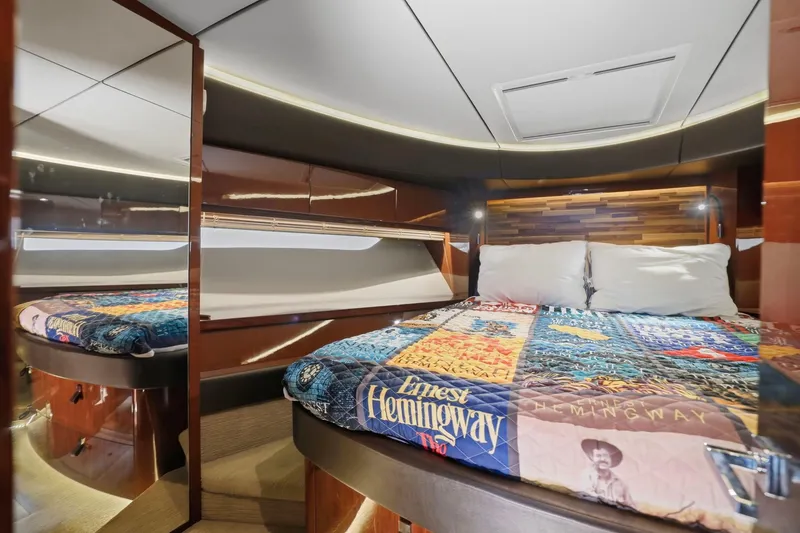 Slide: The Image of Luxurious 2017 Sea Ray L590 yacht cabin with cozy bed and Hemingway-themed quilt. - 104