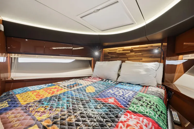Slide: The Image of Luxurious 2017 Sea Ray L590 yacht cabin with colorful quilt and modern lighting. - 105