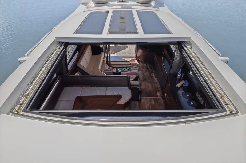 Slide: The Image of 2017 Sea Ray L590 yacht interior with open sunroof, showcasing luxurious seating and wooden flooring. - 26