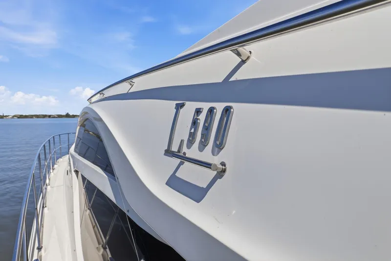 Slide: The Image of 2017 Sea Ray L590 yacht side view on calm water under blue sky. - 35