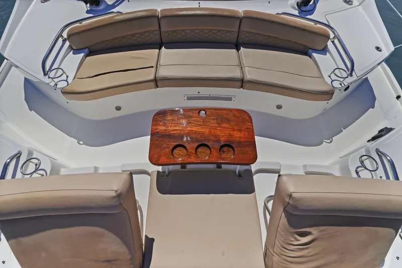 Slide: The Image of Luxurious seating area on a 2017 Sea Ray L590 yacht with a wooden table. - 45