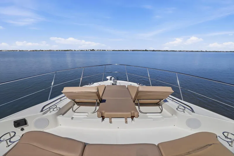 Slide: The Image of 2017 Sea Ray L590 yacht deck with lounge chairs overlooking calm ocean waters. - 49