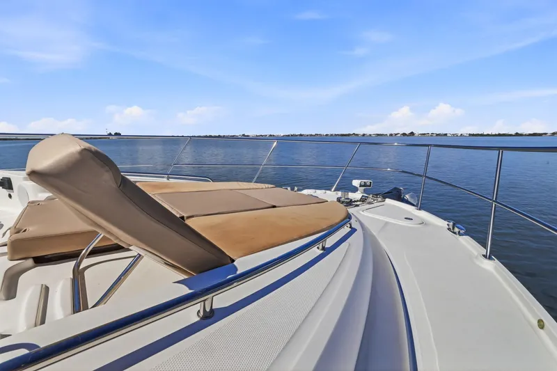 Slide: The Image of Luxurious 2017 Sea Ray L590 yacht with sunbed, overlooking serene waters. - 55