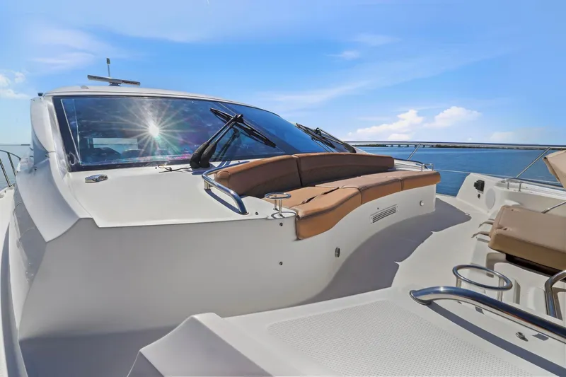 Slide: The Image of 2017 Sea Ray L590 yacht deck with seating, under clear blue sky. - 57