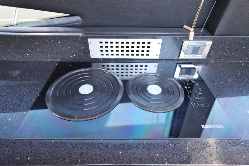 Slide: The Image of Kenyon electric cooktop on 2017 Sea Ray L590 yacht, featuring sleek black countertop design. - 59
