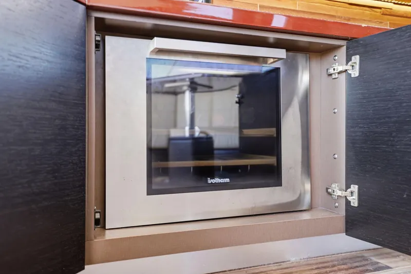 Slide: The Image of Built-in oven on 2017 Sea Ray L590 yacht, with open cabinet doors. - 61