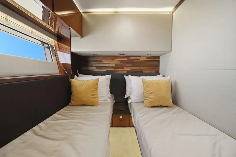Slide: The Image of Luxurious 2017 Sea Ray L590 yacht cabin with twin beds and elegant decor. - 87