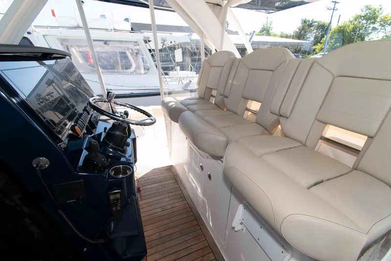 Slide: The Image of 2019 Pursuit S 408 Sport boat interior with beige seating and steering console. - 10