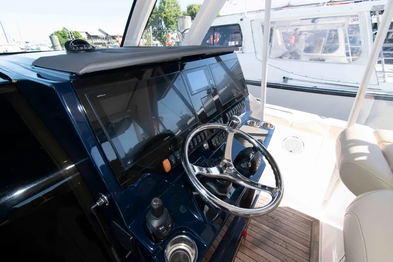 Slide: The Image of 2019 Pursuit S 408 Sport boat helm with modern controls and navigation screens. - 11