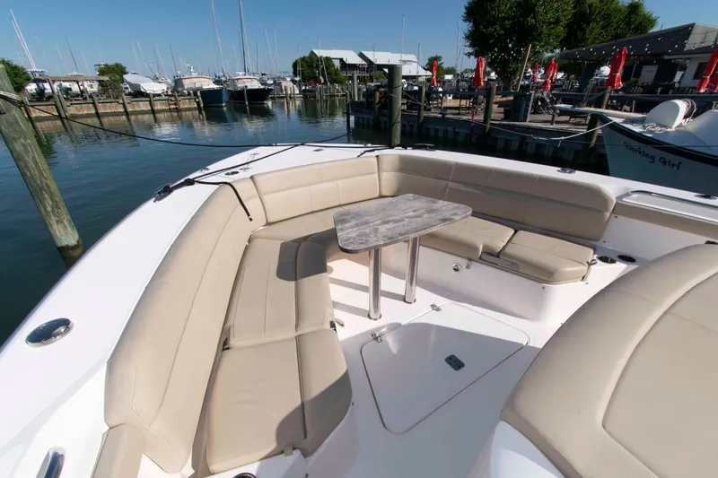 Slide: The Image of 2019 Pursuit S 408 Sport boat with beige seating and table at marina. - 18