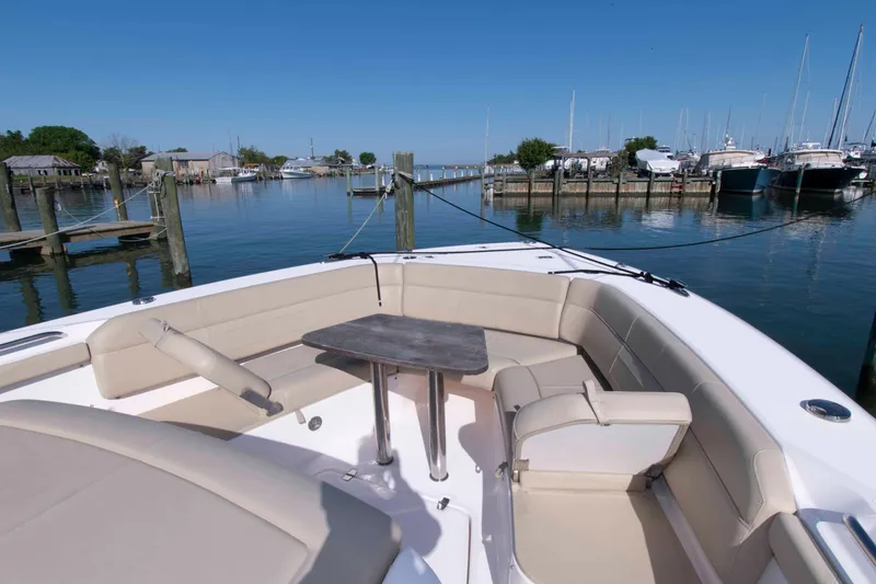 Slide: The Image of 2019 Pursuit S 408 Sport boat with spacious seating in a marina setting. - 19