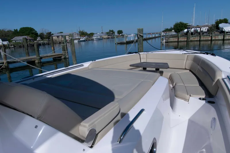 Slide: The Image of 2019 Pursuit S 408 Sport boat with spacious seating and table, docked in a serene marina. - 22