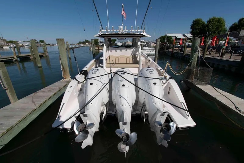 Slide: The Image of 2019 Pursuit S 408 Sport boat docked with triple outboard engines. - 25