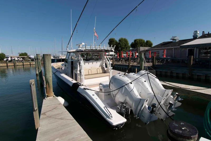 Slide: The Image of 2019 Pursuit S 408 Sport boat docked at marina with triple outboard engines. - 26