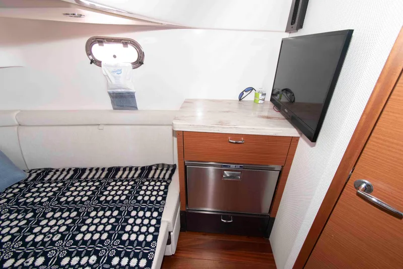 Slide: The Image of 2019 Pursuit S 408 Sport cabin interior with bed, TV, and storage. - 31
