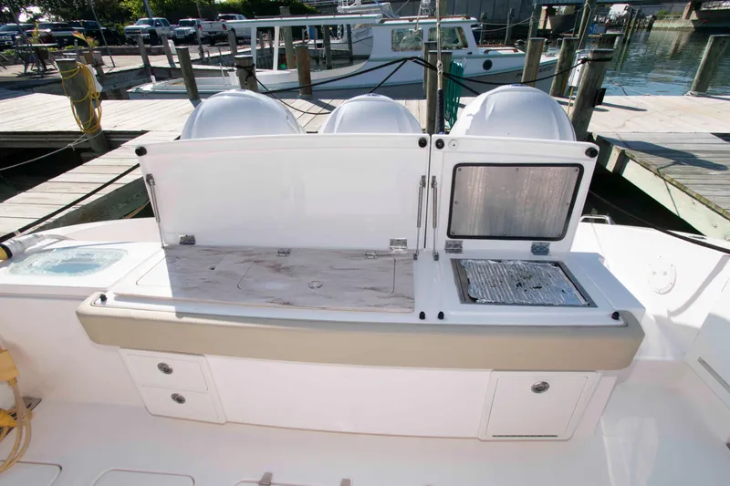 Slide: The Image of 2019 Pursuit S 408 Sport boat with open storage compartments at the dock. - 7