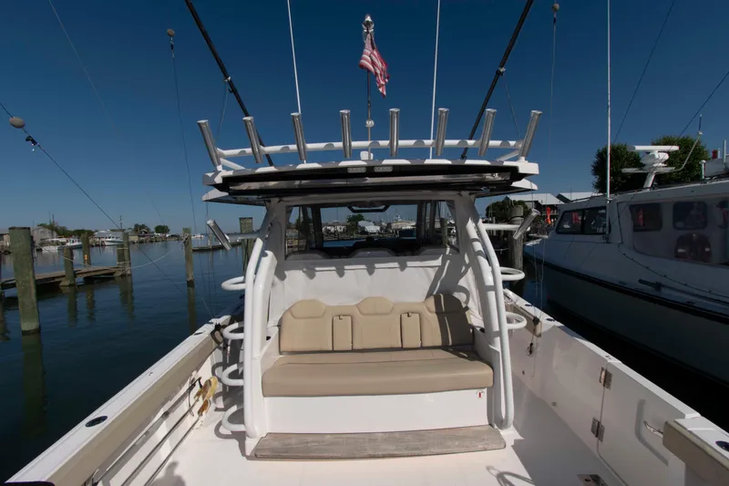 Slide: The Image of 2019 Pursuit S 408 Sport boat docked, featuring spacious seating and fishing rod holders. - 9