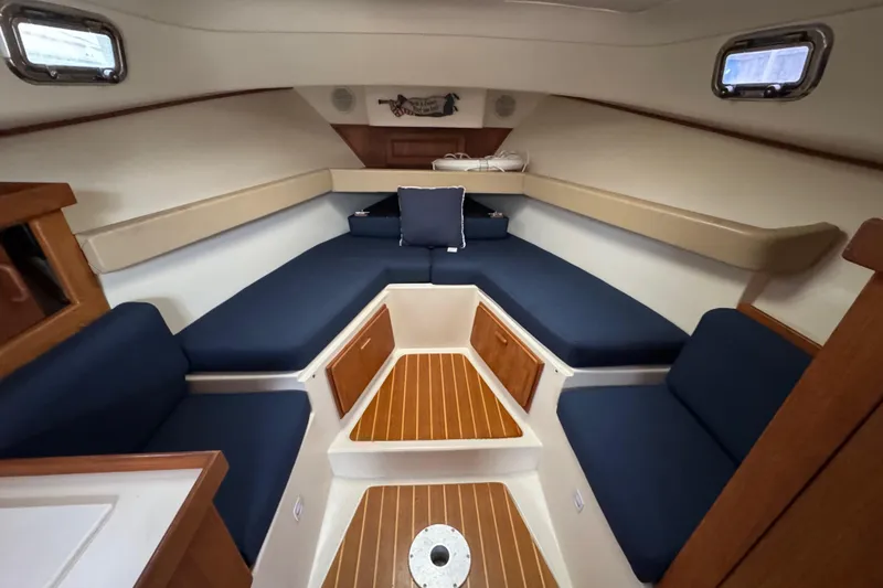 Slide: The Image of 2001 Mainship Pilot 30 cabin interior with blue seating and wooden accents. - 11