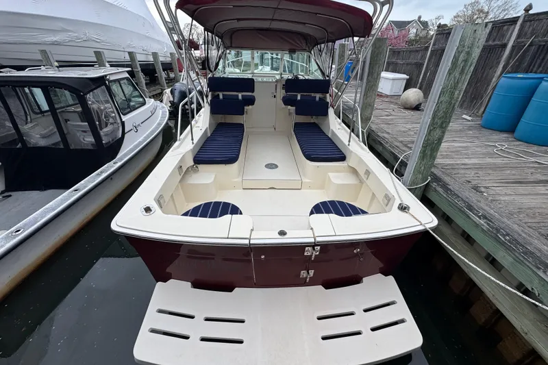 Slide: The Image of 2001 Mainship Pilot 30 boat docked, featuring spacious seating and canopy. - 3