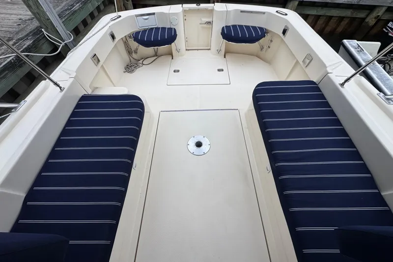 Slide: The Image of 2001 Mainship Pilot 30 boat interior with striped navy seating and spacious deck. - 6