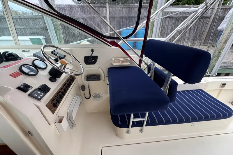 Slide: The Image of 2001 Mainship Pilot 30 helm with blue seating and navigational controls. - 7