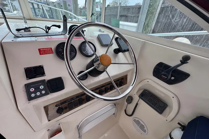 Slide: The Image of 2001 Mainship Pilot 30 helm with steering wheel, gauges, and control panel. - 8