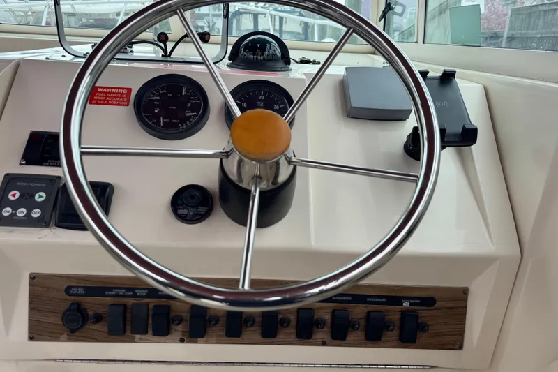 Slide: The Image of 2001 Mainship Pilot 30 helm with steering wheel, gauges, and control panel. - 9