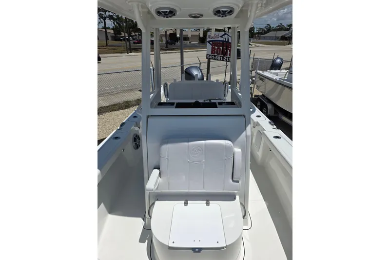 Slide: The Image of 2026 Parker 254 FATHOM boat interior with seating and console, parked outdoors. - 12