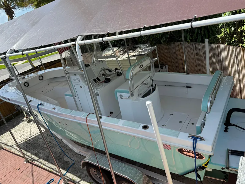 Slide: The Image of 2023 Dusky 252 boat under canopy, parked on trailer, side view. - 11