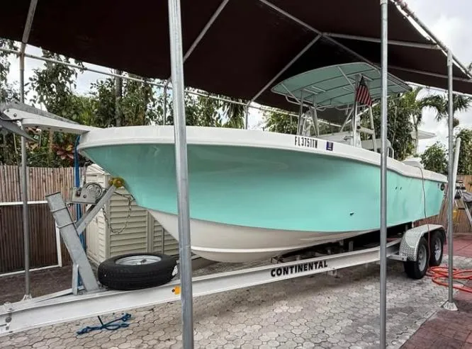 Slide: The Image of 2023 Dusky 252 boat on trailer under canopy, mint green hull. - 3