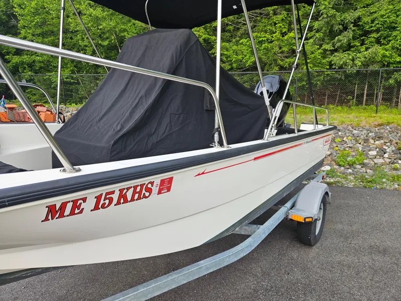 Slide: The Image of 2008 Boston Whaler 170 Montauk boat on trailer, covered, parked on asphalt. - 5