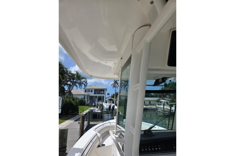 Slide: The Image of 2017 Boston Whaler 250 Outrage boat docked near waterfront homes. - 13