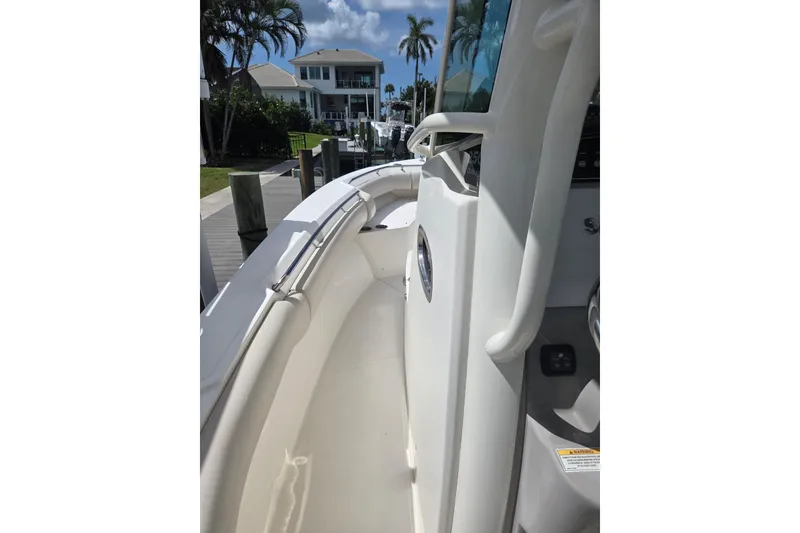 Slide: The Image of 2017 Boston Whaler 250 Outrage boat docked, showcasing sleek design and spacious deck. - 14