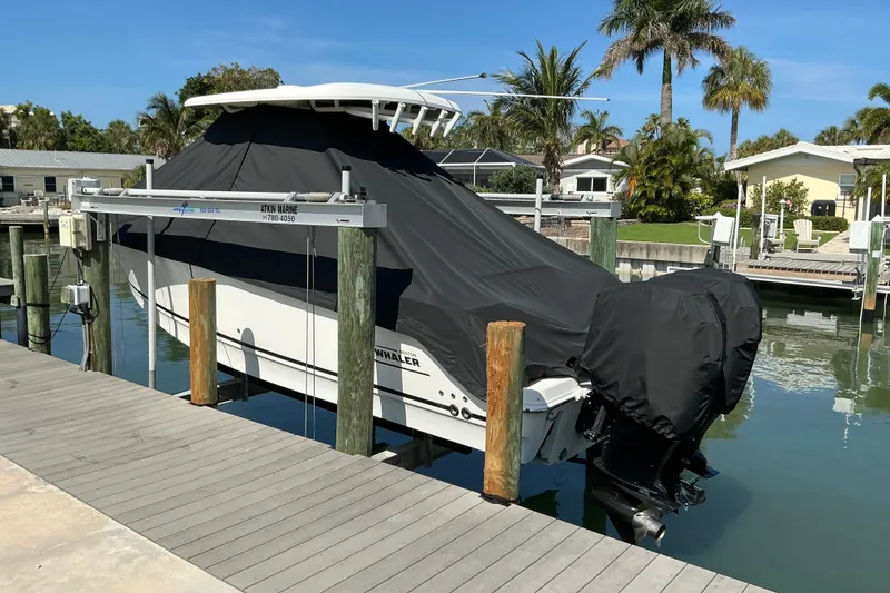 Slide: The Image of 2017 Boston Whaler 250 Outrage boat covered and docked at a marina. - 21