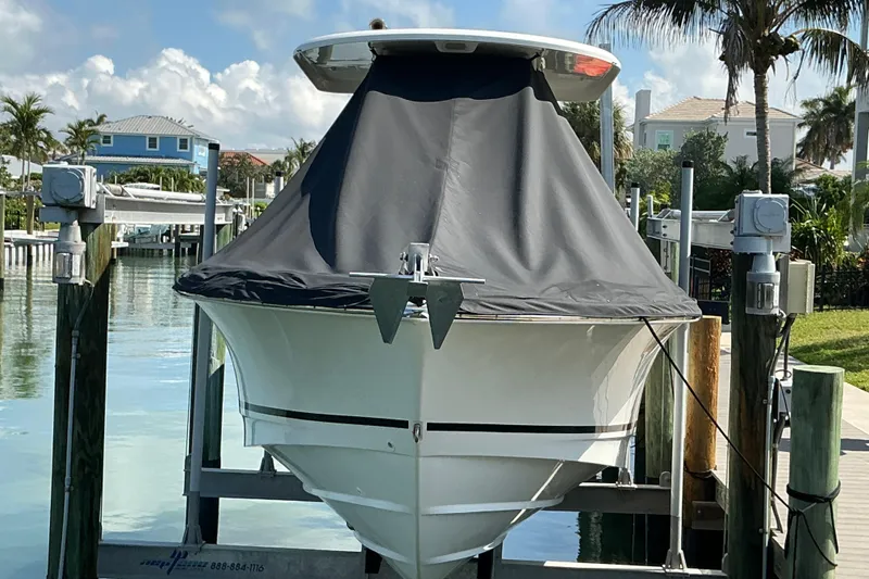 Slide: The Image of 2017 Boston Whaler 250 Outrage boat docked with cover, surrounded by tropical scenery. - 23