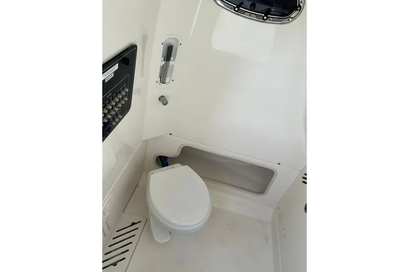 Slide: The Image of Interior view of 2017 Boston Whaler 250 Outrage boat's compact bathroom area. - 29