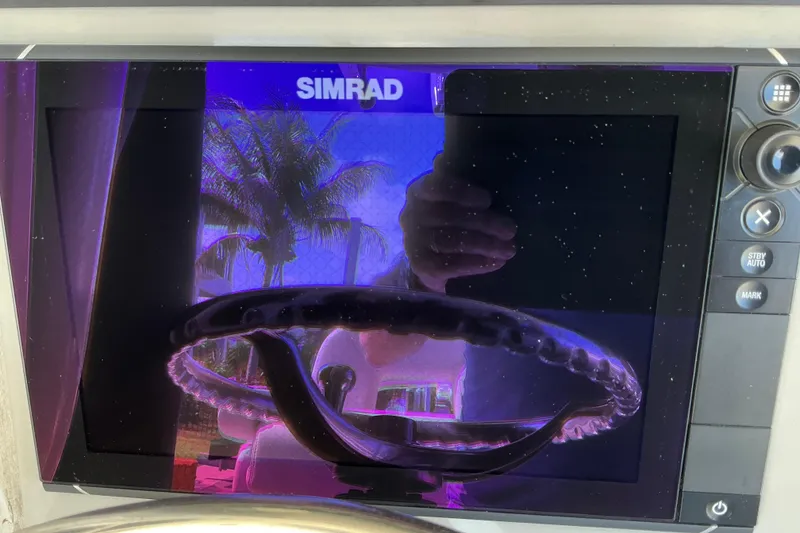 Slide: The Image of Simrad display on 2017 Boston Whaler 250 Outrage, reflecting palm trees and steering wheel. - 36