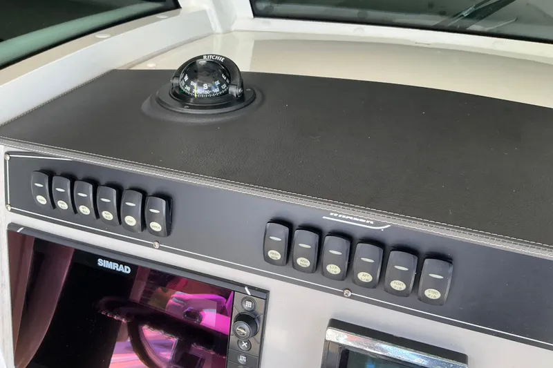 Slide: The Image of Control panel of a 2017 Boston Whaler 250 Outrage with compass and Simrad display. - 37