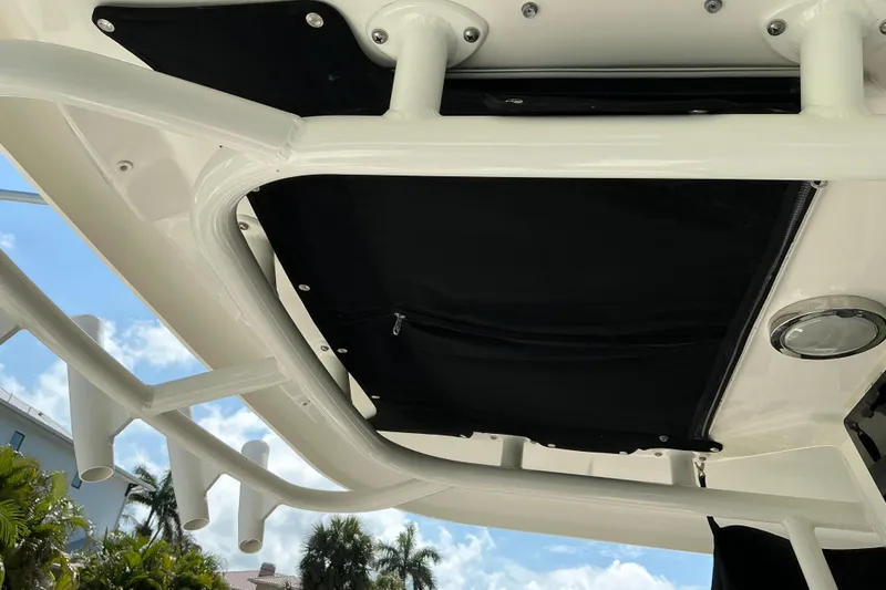 Slide: The Image of 2017 Boston Whaler 250 Outrage T-top with rod holders and black canvas cover. - 45
